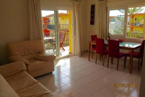 a living room with a couch and a table and chairs at Pl Les Bovetes Apt in Denia