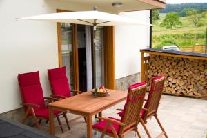a wooden table with chairs and an umbrella on a patio at Apartament Góralka in Jaworki