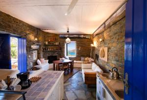 a kitchen and living room with a stone wall at Stone house with a magical view in Otzias