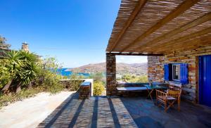 a stone house with a table and chairs on a patio at Stone house with a magical view in Otzias