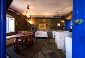 eine Küche und ein Wohnzimmer mit einem Tisch und einer Couch in der Unterkunft Stone house with a magical view in Otziás