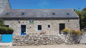 una casa in pietra con una panchina davanti di Maison Ti ar raniged a Beuzec-Cap-Sizun