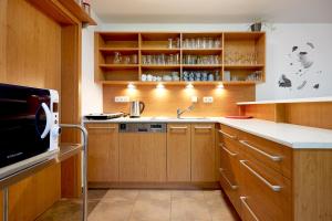 a kitchen with wooden cabinets and a microwave at Vila Poule in Bohutín