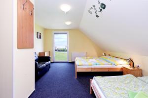 a bedroom with two beds and a couch and a window at Vila Poule in Bohutín