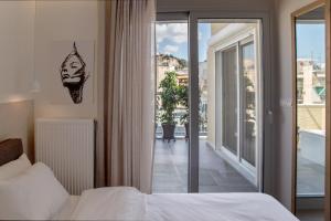 a bedroom with a bed and a view of a balcony at Athens Luxury in Athens