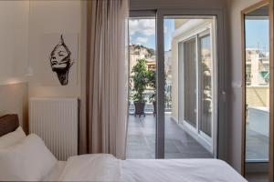 Un dormitorio con una cama y vista a un balcón. en Athens Luxury, en Atenas