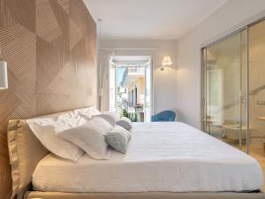 łóżko z białą pościelą i poduszkami w sypialni w obiekcie AQUAMADRE Suites w mieście Carloforte