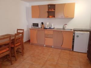 a small kitchen with a table and a refrigerator at Casutele Intim in Costinesti