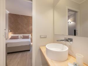 een badkamer met een wastafel en een bed bij AQUAMADRE Suites in Carloforte