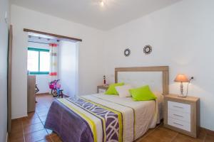 um quarto com uma cama com almofadas verdes em Apartamento Martina em Puerto del Carmen