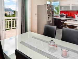 uma cozinha com uma mesa com cadeiras e um frigorífico em Apartments LUPE em Split