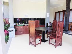 eine Küche und ein Esszimmer mit Tisch und Stühlen in der Unterkunft Plawa Bali Guest House in Canggu