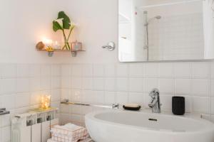 La salle de bains blanche est pourvue d'un lavabo et d'un miroir. dans l'établissement Canonica 16, à La Spezia