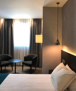 Habitación de hotel con cama, mesa y sillas en HG City Suites Barcelona, en Barcelona