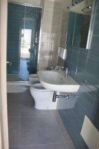 bagno con lavandino, servizi igienici e specchio di La Torre costiera a Torre dell'Orso