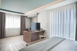1 dormitorio con 1 cama y escritorio con TV en Modica Beach Resort en Marina di Modica