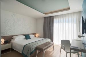 A bed or beds in a room at Modica Beach Resort