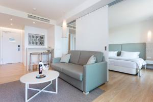 a living room with a couch and a bed at Palmares Beach House Hotel - Adults Only in Lagos