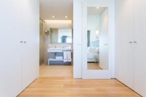 a white bathroom with a sink and a mirror at Palmares Beach House Hotel - Adults Only in Lagos