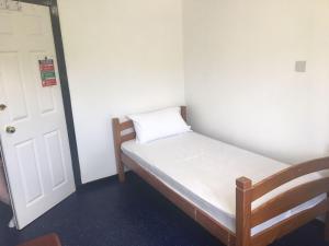 a small bed in a room with a door at Ledgowan Bunkhouse in Achnasheen