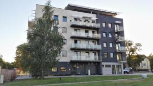 a tall building with a tree in front of it at Sunny Apartment I in Koszalin