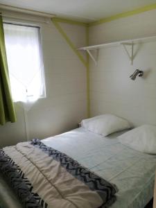 a bed in a room with a window at camping Le Kermadec in Ambon