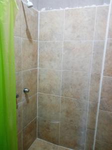 a shower stall with a glass door with a tiled shower at Posada El Balcon in Rincon de Guayabitos