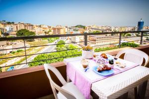 a table with a plate of food on a balcony at A View on Cagliari in Cagliari