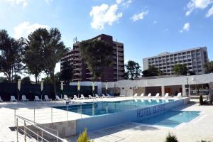 uma piscina com espreguiçadeiras e um edifício em Hotel Olimpic em Jupiter