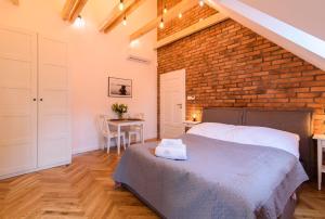 a bedroom with a brick wall and a bed and a table at Apartamenty Rydzewo in Rydzewo