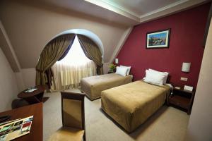 a hotel room with two beds and a window at Hotel Praha in Uzhhorod