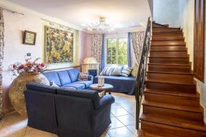 un soggiorno con divano blu e scale di Villa Lisa a Diano Marina
