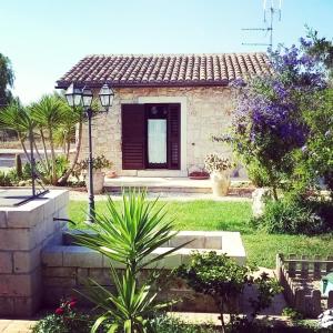 a small house with a yard with a plant at B&B Villa Giusy in Siracusa
