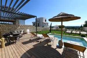 ヴィルヌーヴ・レ・ザヴィニョンにあるLes Loges En Provence "Villa Garrigue"のデッキ(椅子、パラソル付)、プールが備わります。