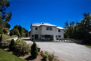 uma grande casa branca com uma entrada para carros em Inch View Lodge em Milltown