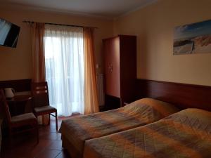 een hotelkamer met 2 bedden en een raam bij Posejdon in Ustronie Morskie
