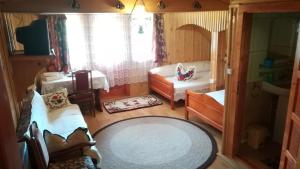 een kleine kamer met een bed en een bank bij Pensiunea Maria in Rohia