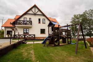 a playground in front of a house at Apartamenty Rydzewo in Rydzewo