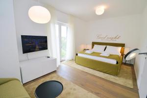 ein Schlafzimmer mit einem Bett, einem TV und einem Sofa in der Unterkunft Plage Lovran Residence in Lovran