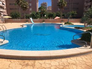 a large pool with blue water in a building at Playa Lisa Studio in Santa Pola