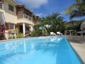 a large blue swimming pool in front of a house at Villa Kreola in Grande Gaube