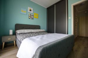 a bedroom with a bed and a blue wall at Apartament u stóp Śnieżki in Karpacz