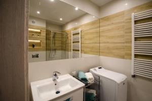 a bathroom with a sink and a toilet and a mirror at Apartament u stóp Śnieżki in Karpacz