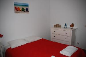 ヴィラ・ノヴァ・デ・ミルフォンテスにあるCasa Sobralのベッドルーム1室(赤いベッド1台、ドレッサー付)