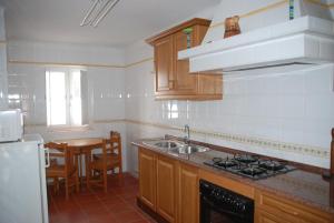 a kitchen with a sink and a stove top oven at Casa Sobral in Vila Nova de Milfontes