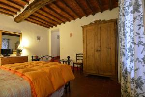 a bedroom with a bed and a wooden cabinet at La FIABA in Castellina in Chianti