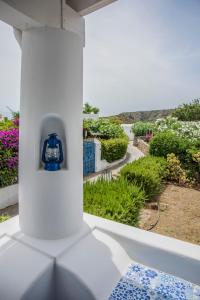 Una botella azul sentada en una columna blanca en un balcón en La Sirena, en Panarea