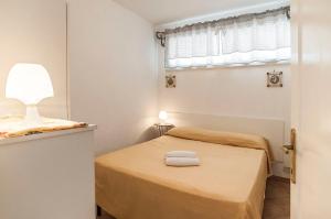 a small bedroom with a bed and a window at Appartamento Dani in Sperlonga