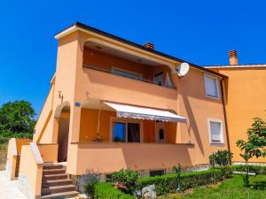 a yellow house with stairs in front of it at Apartment Dragica in Ližnjan