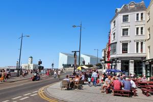 a group of people sitting at tables on a city street at Macatsim Seaview Sunset in Margate